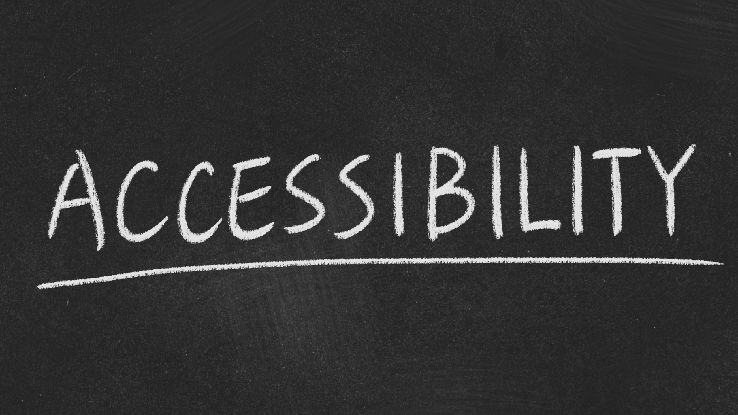 "The word 'Accessibility' written in white chalk on a blackboard, underlined.